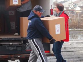Pat Doherty, President of Oceanside American LL, carries a box to its new home